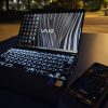 夜の公園のテーブルに置いたVAIOとスマートフォン