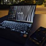 夜の公園のテーブルに置いたVAIOとスマートフォン
