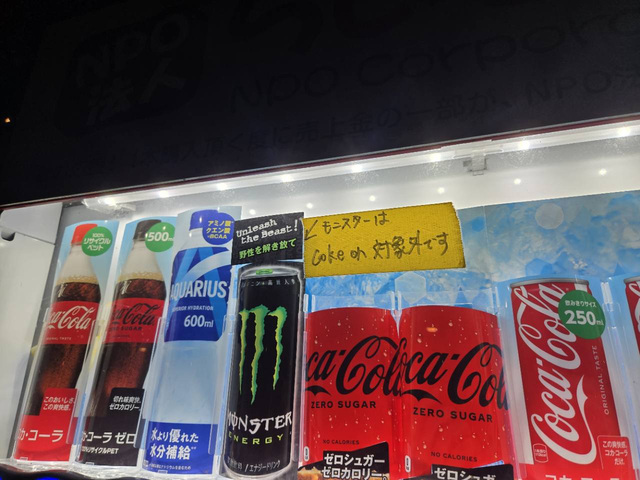 自動販売機に貼られた「モンスターはCoke ON対象外です」の手書き案内